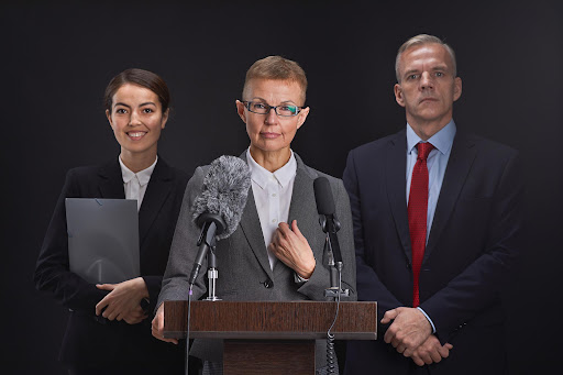 Leaders standing behind a podium with multiple microphones at a formal press conference.