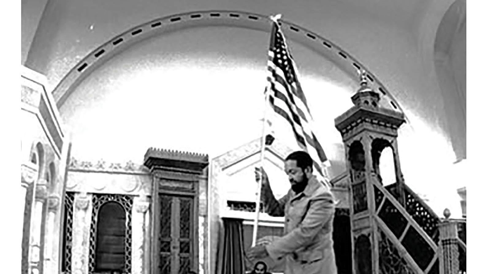 A speaker addressing an audience from a podium.